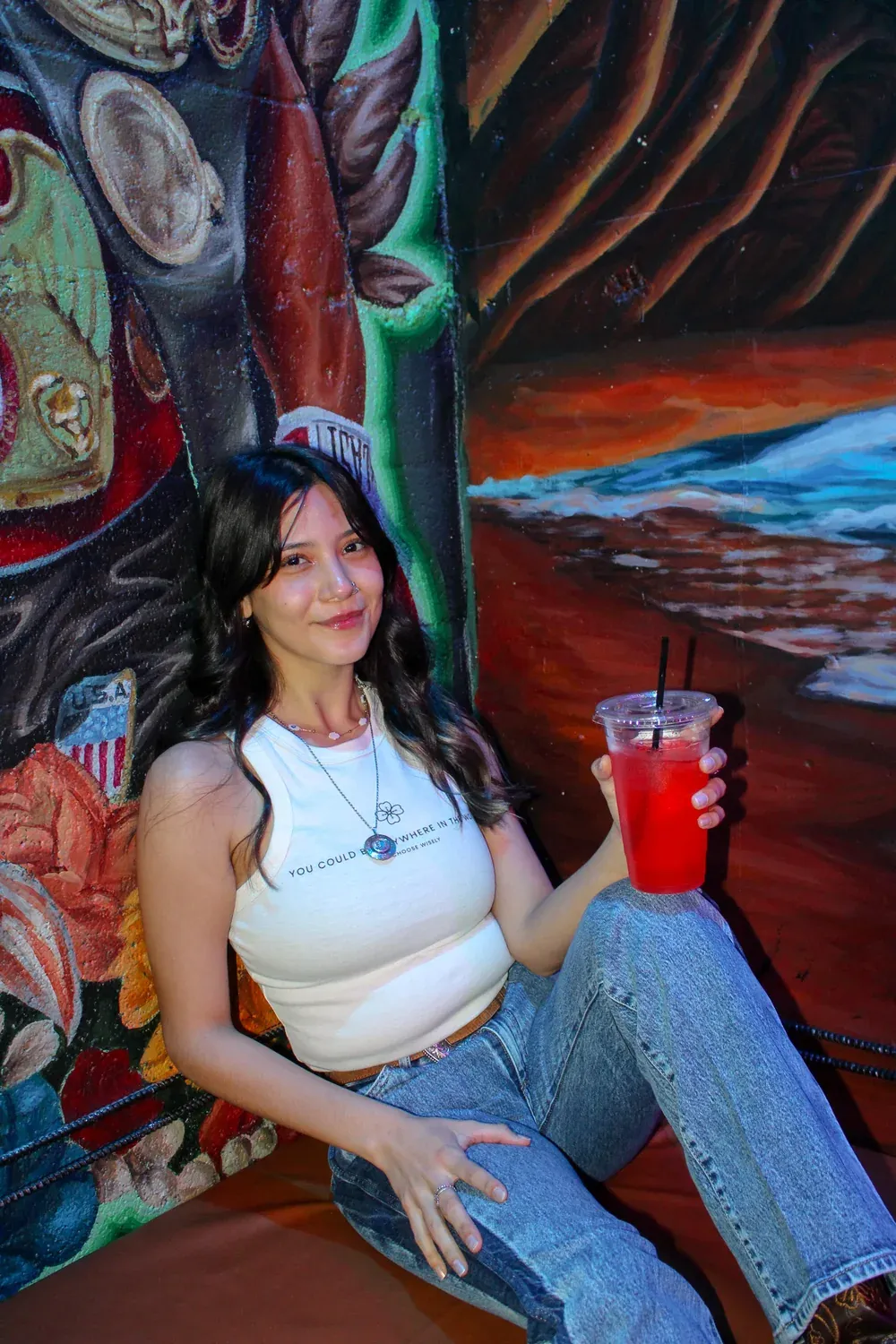 Isabel seated inside Black Klover with a red drink