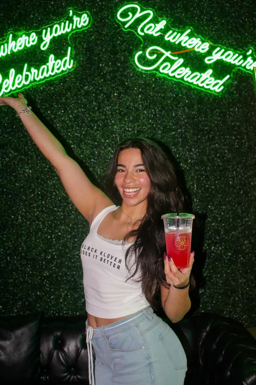 Maria Jose smiling with a red drink inside Black Klover